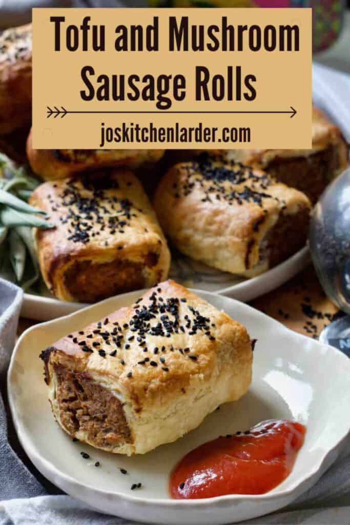 Tofu and mushroom sausage roll on a plate and more on a plate in the background.