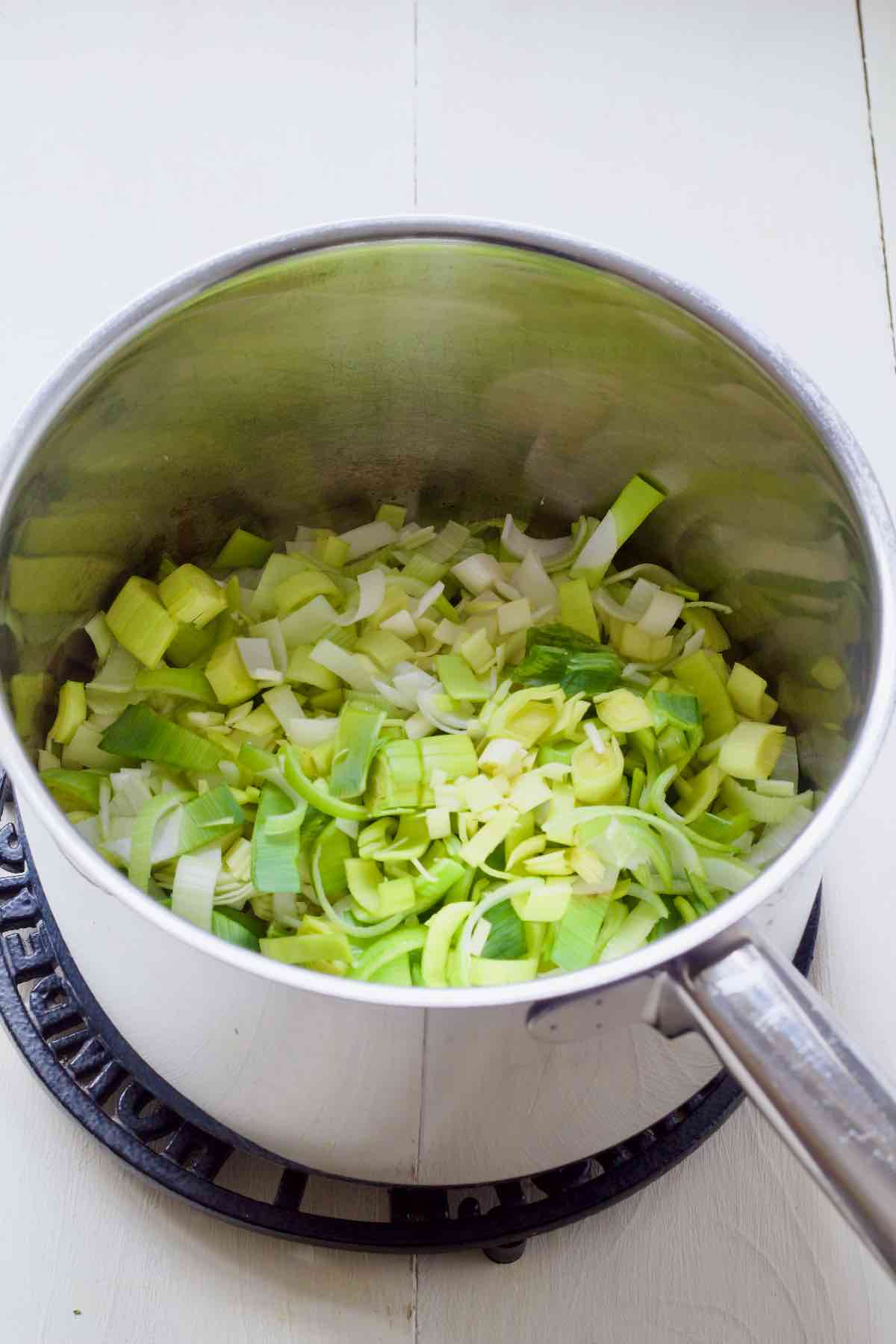 Sliced leek being sautéed in oil and butter.