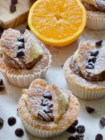 Close up of three chocolate orange butterfly cakes - square.