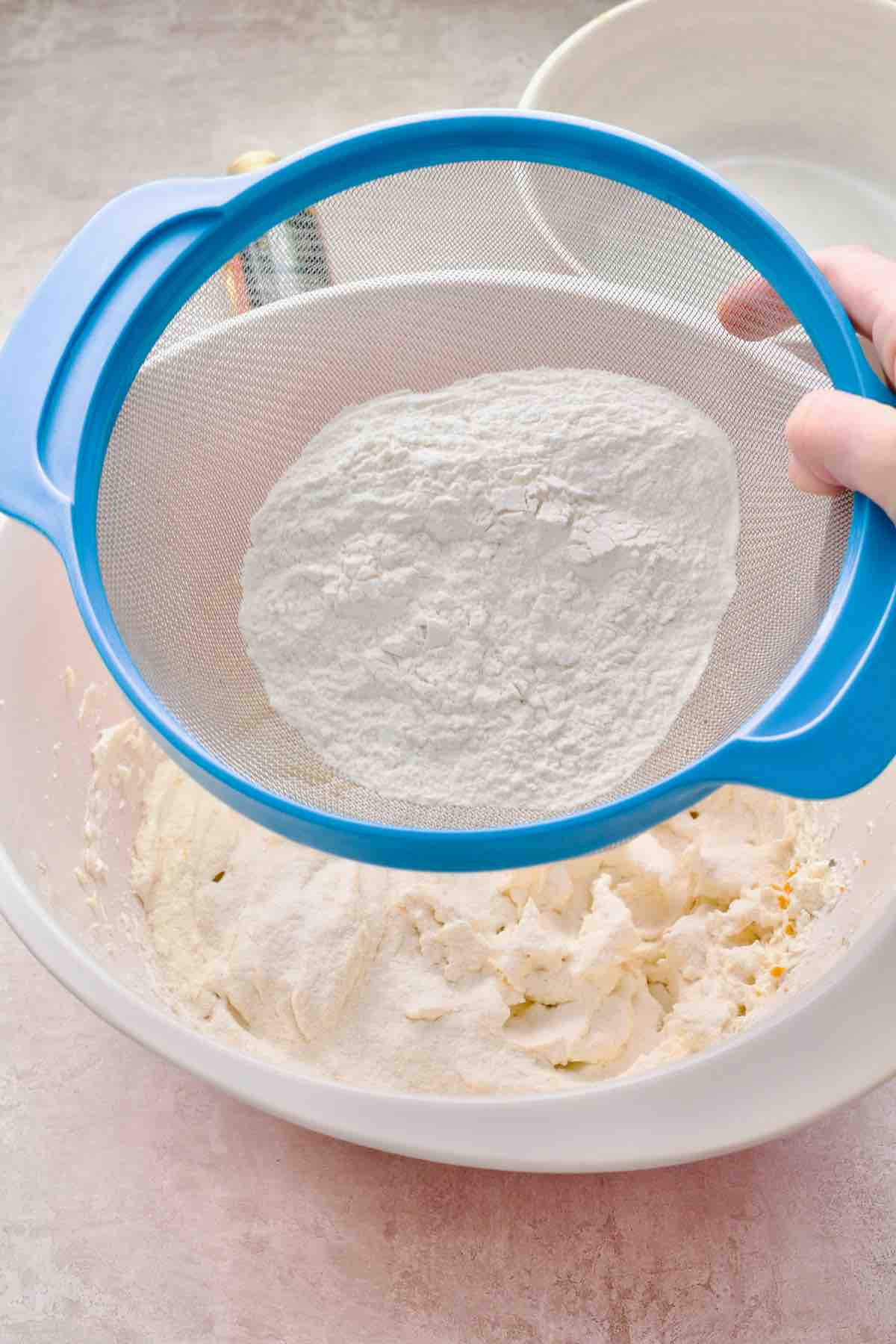 Sieving the flour into egg/sugar/butter mix.