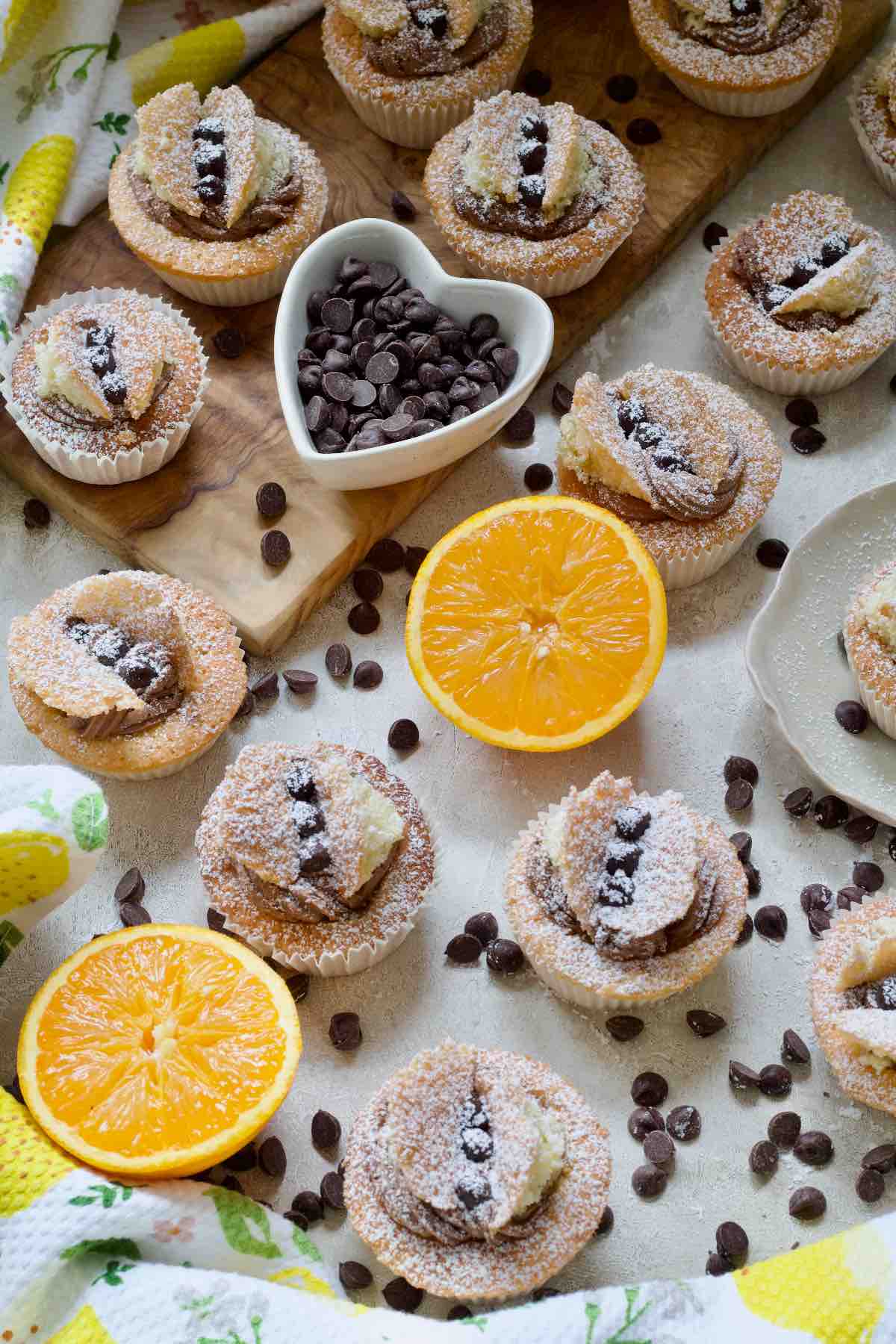 Chocolate orange butterfly cakes with two orange halves and chocolate chips.