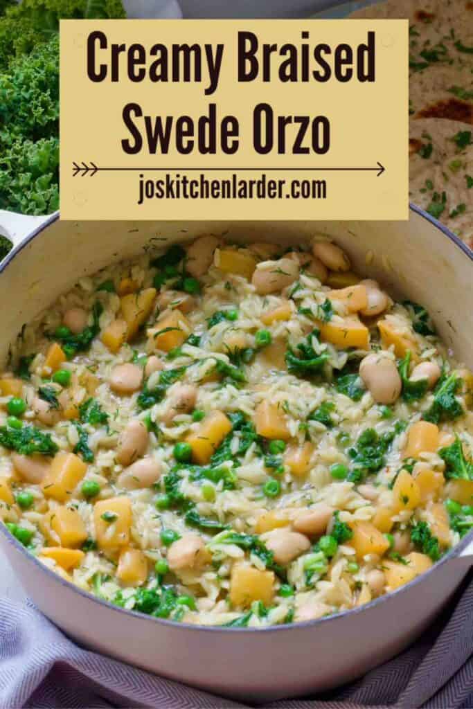 Pot with creamy braised swede orzo, garlic flatbreads and fresh kale behind it.