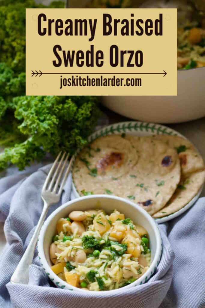 Portion of swede orzo in a bowl wit garlic flatbreads on a plate and pot with rest of orzo and some fresh kale behind.