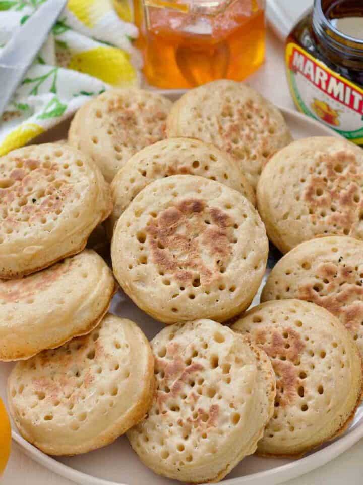 Plate piled up with crumpets.