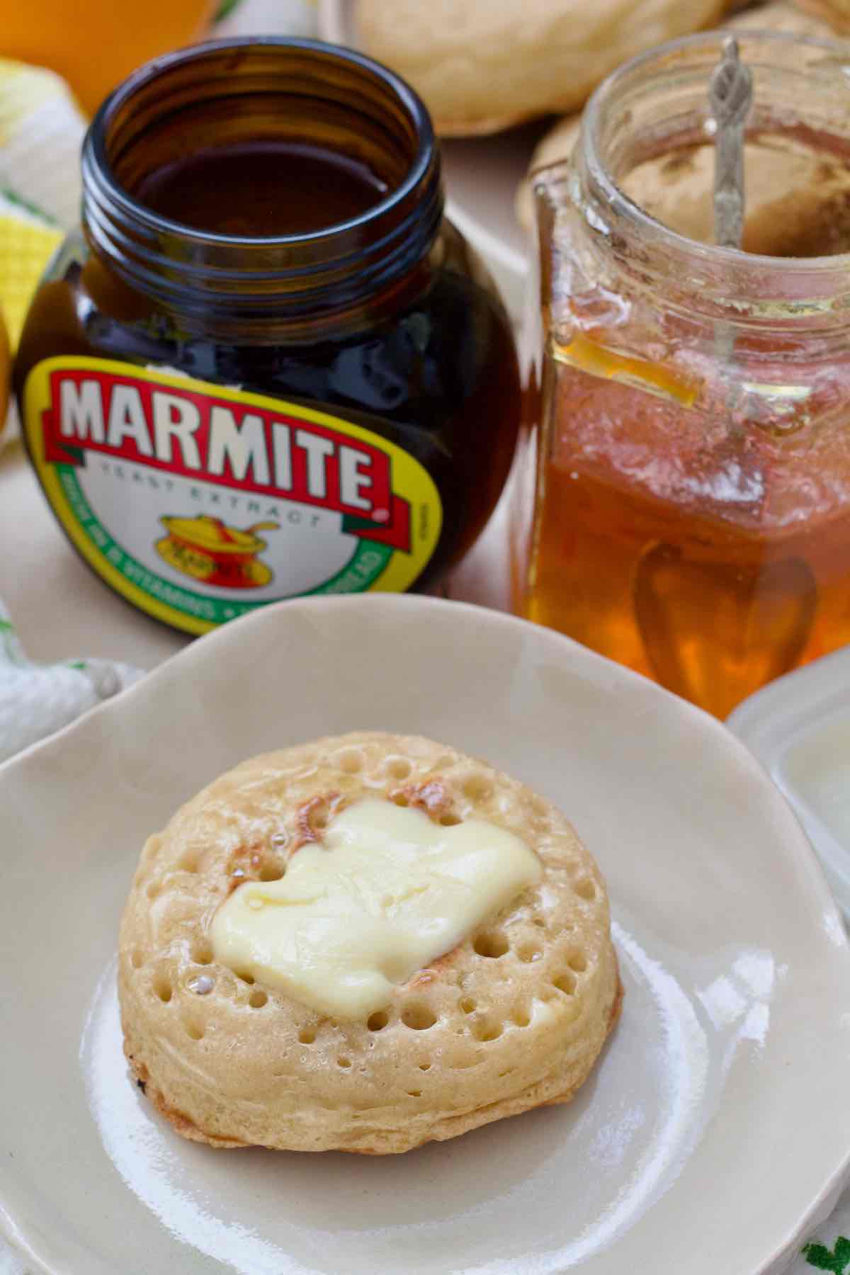 Crumpet with soft piece of butter melting on top of it.