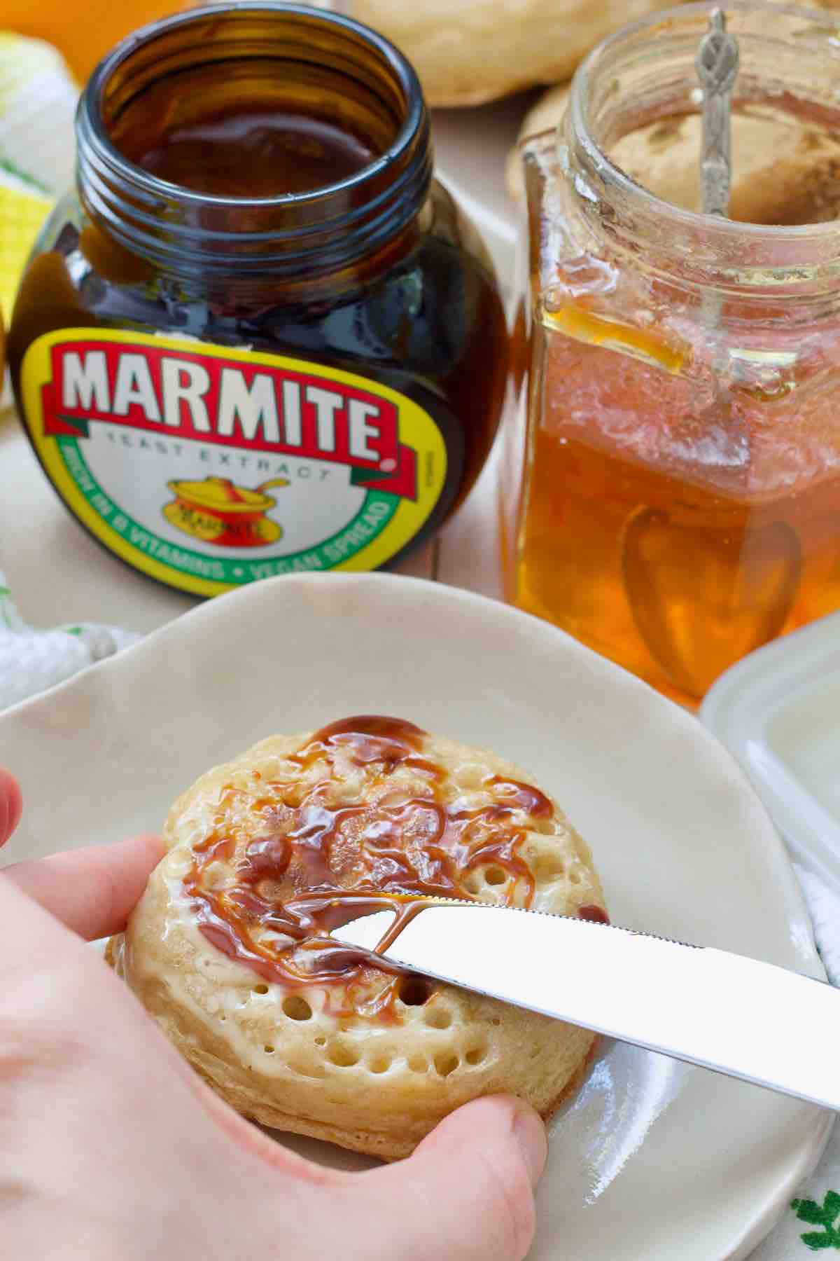 Spreading marmite on a crumpet.