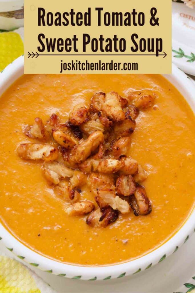 Close up of tomato and sweet potato soup in a serving bowl with crispy beans on top.