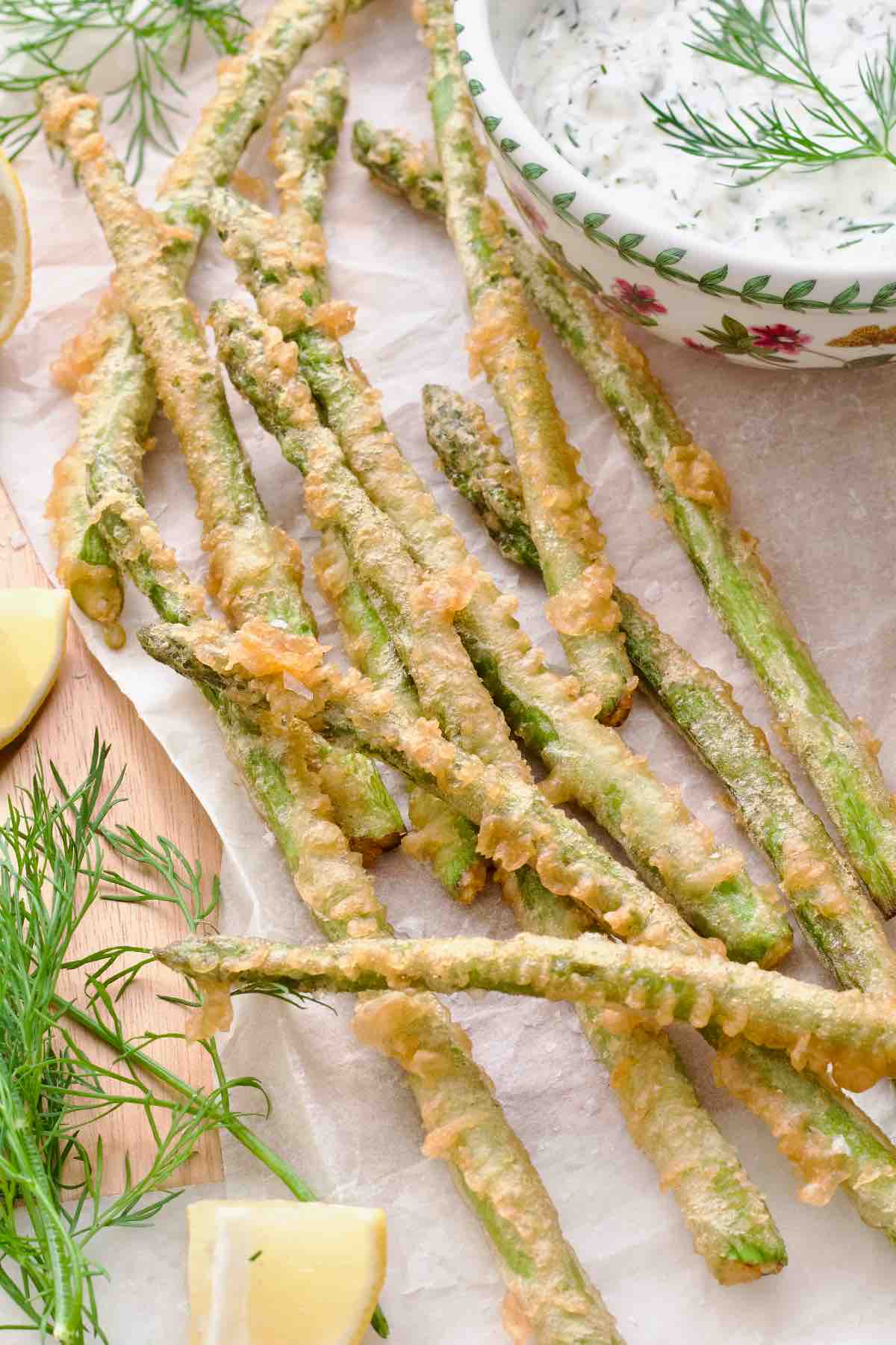 Asparagus tempura served on a parchment paper.