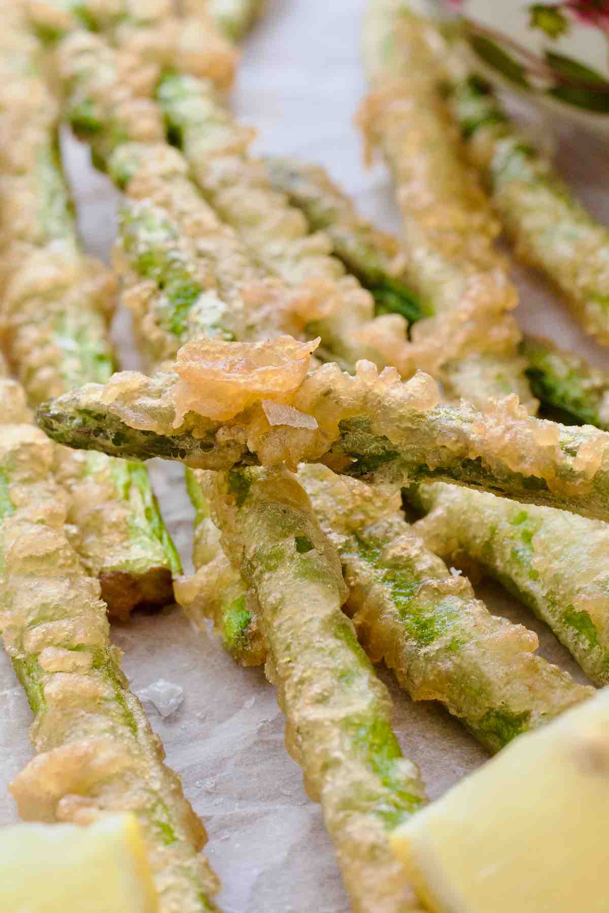 Close up of a deep fried battered tip of asparagus tempura.