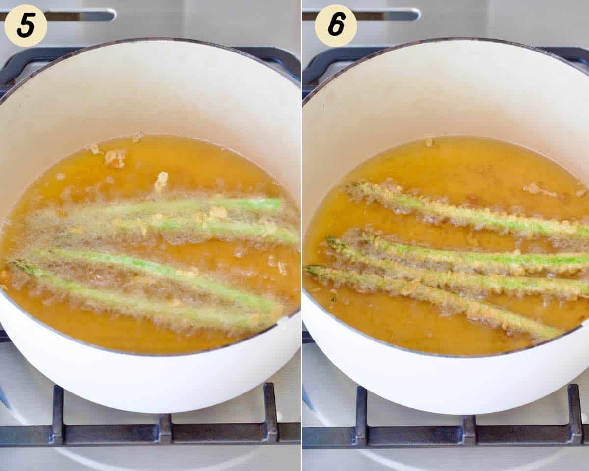 Asparagus tempura deep frying in a large pot.