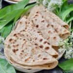 Close up of folded parathas arranged on a platter with wild garlic.