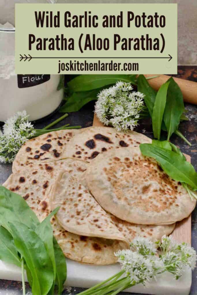 Wild garlic and potato parathas on a board with wild garlic around.
