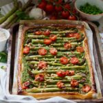Whole asparagus tart on baking tray square photo.