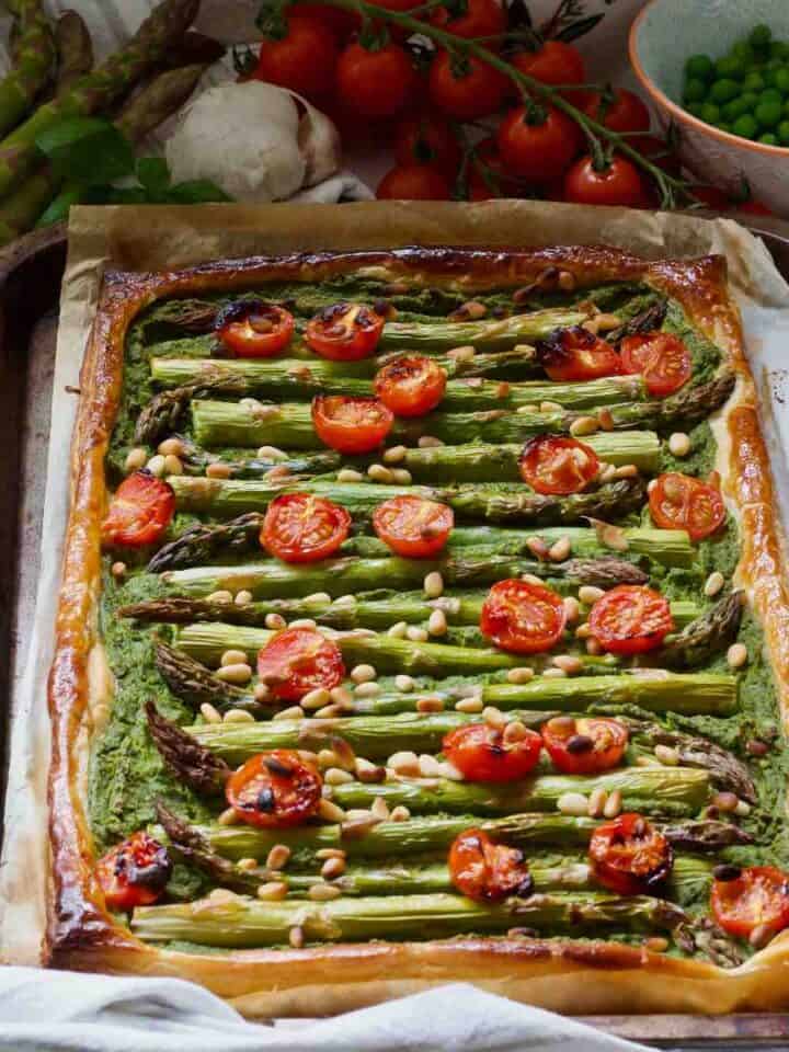 Whole asparagus tart on baking tray square photo.