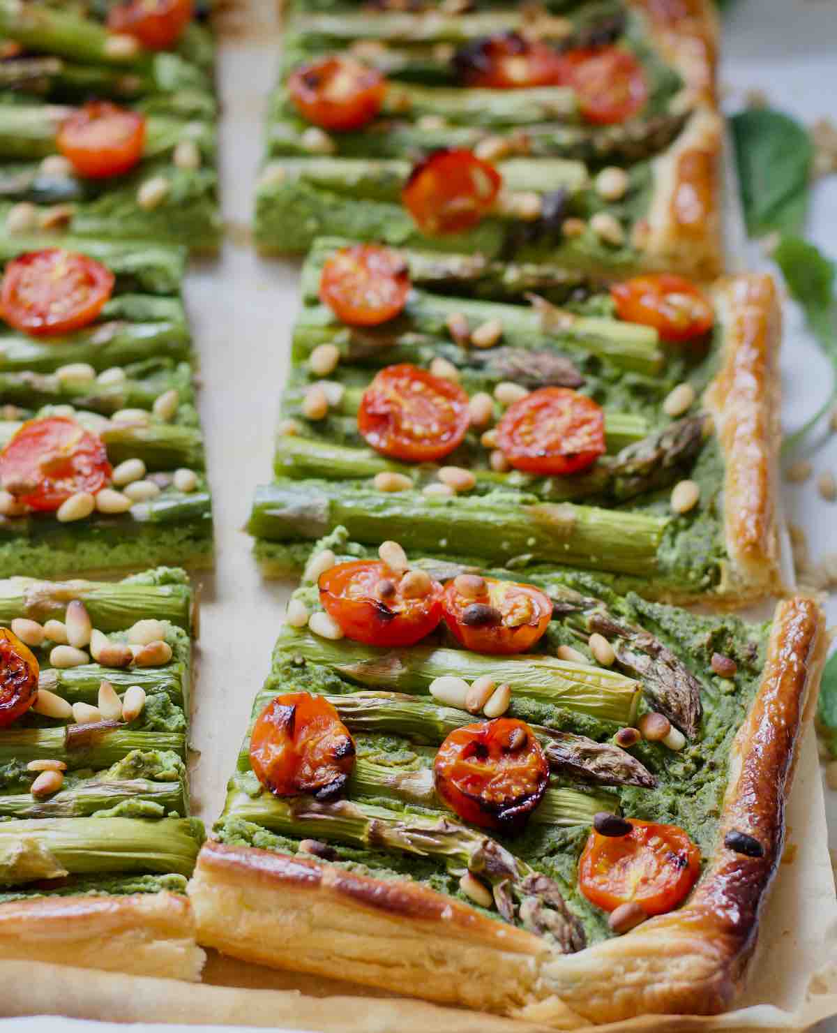 Asparagus tart cut into square sections.