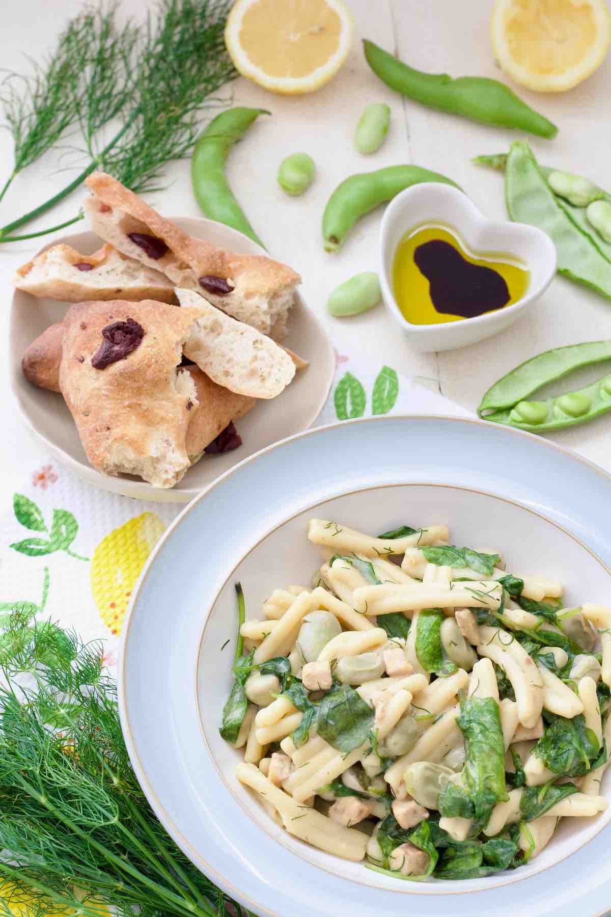 Portion of broad bean pasta in a bowl, bread and olive oil with vinegar for dipping.