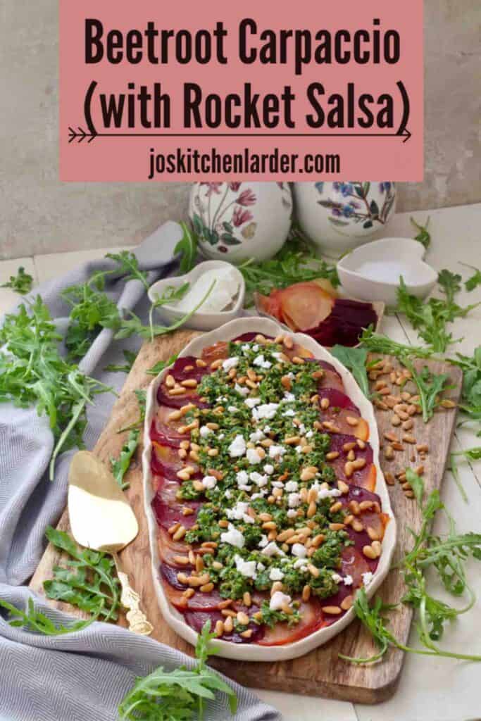 Beetroot carpaccio on a platter, rocket leaves around, two bottles at the back.