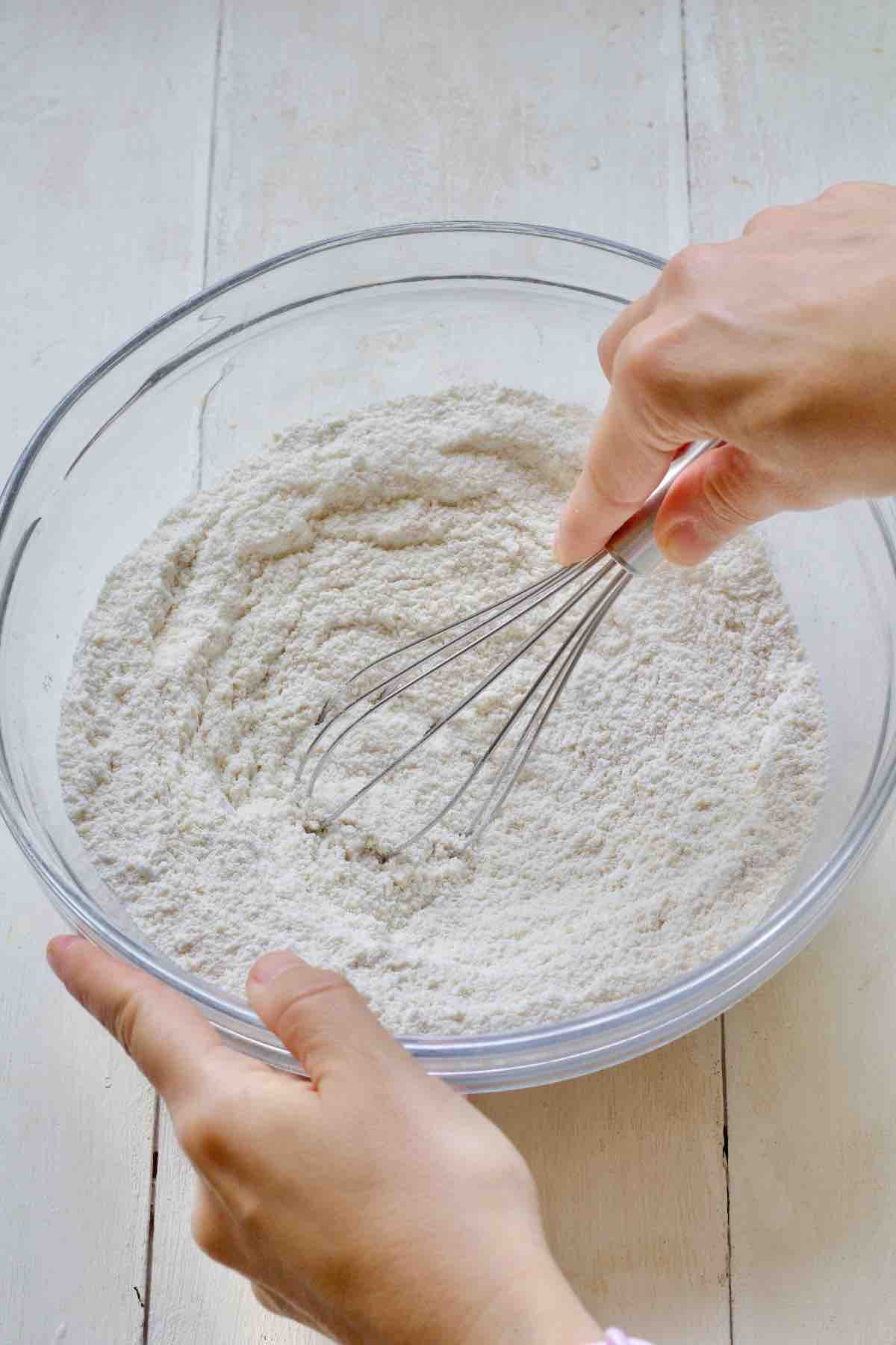 Whisking flour and raising agents in a bowl.