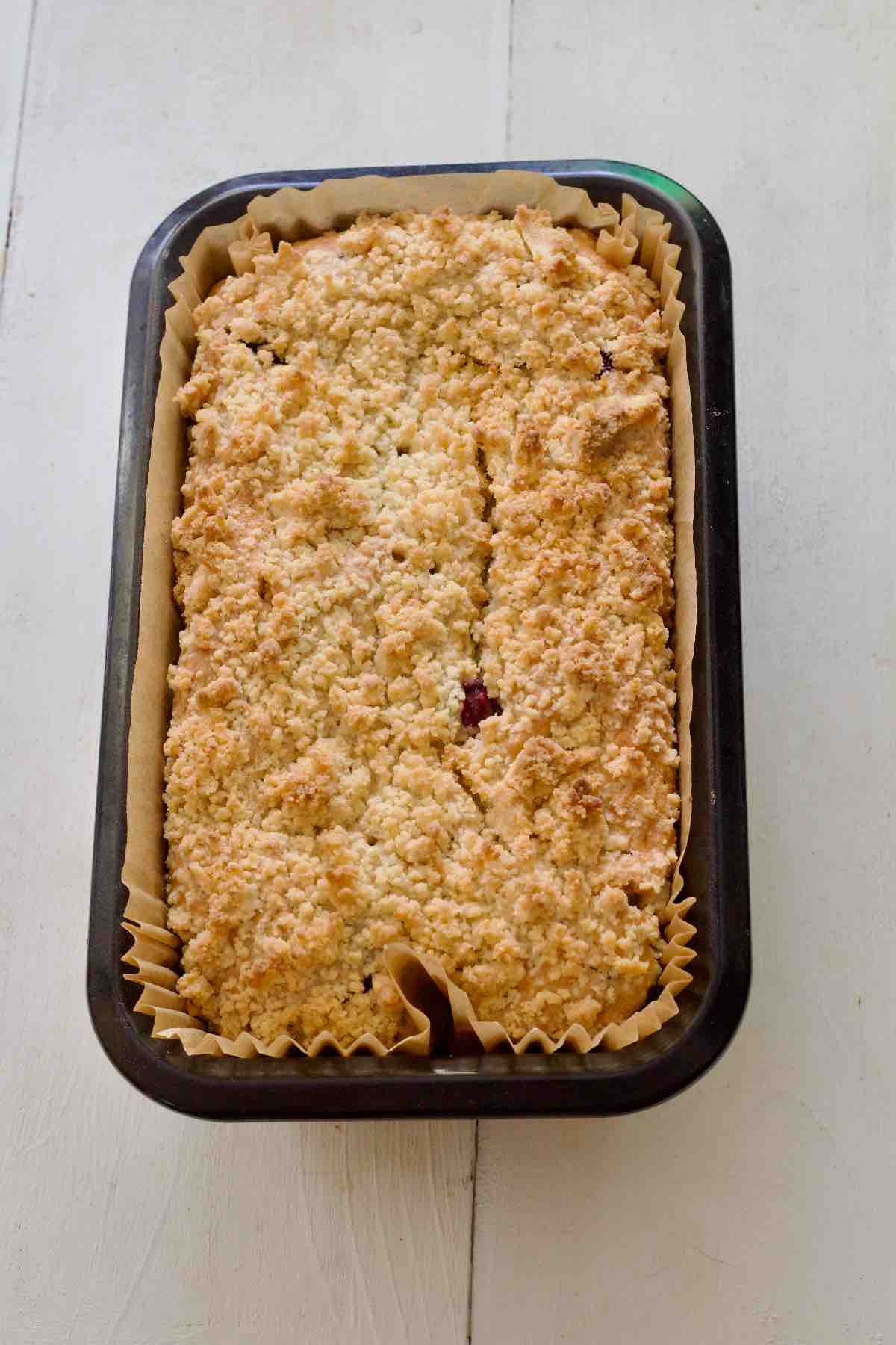 Baked lemon and blueberry loaf cake in a tin.