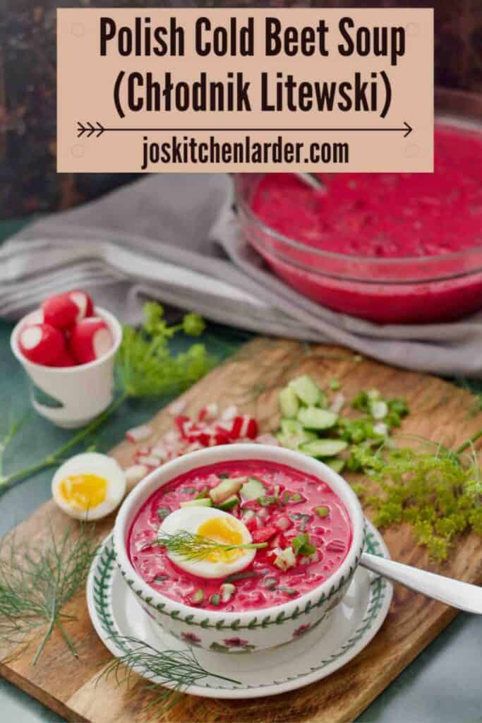 Polish cold beet soup served in a bowl with accompaniments around it and large bowl of chłodnik in the background.