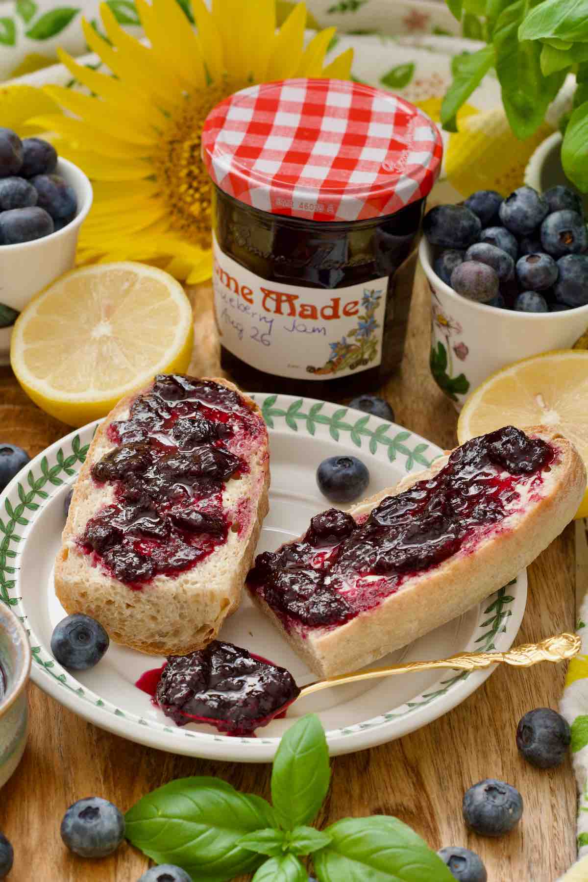 Two pieces of baguette topped with blueberry jam and a jam filled spoon.