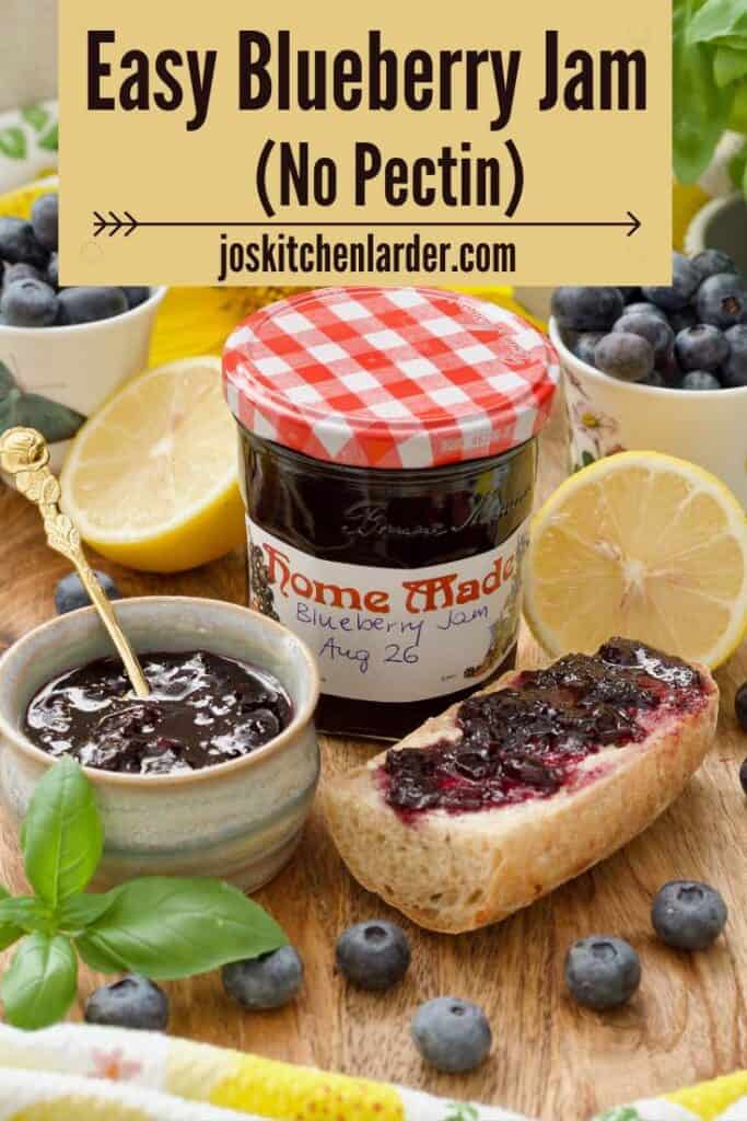 Labelled jar with blueberry jam, jam in a small bowl and a piece of jam topped baguette.