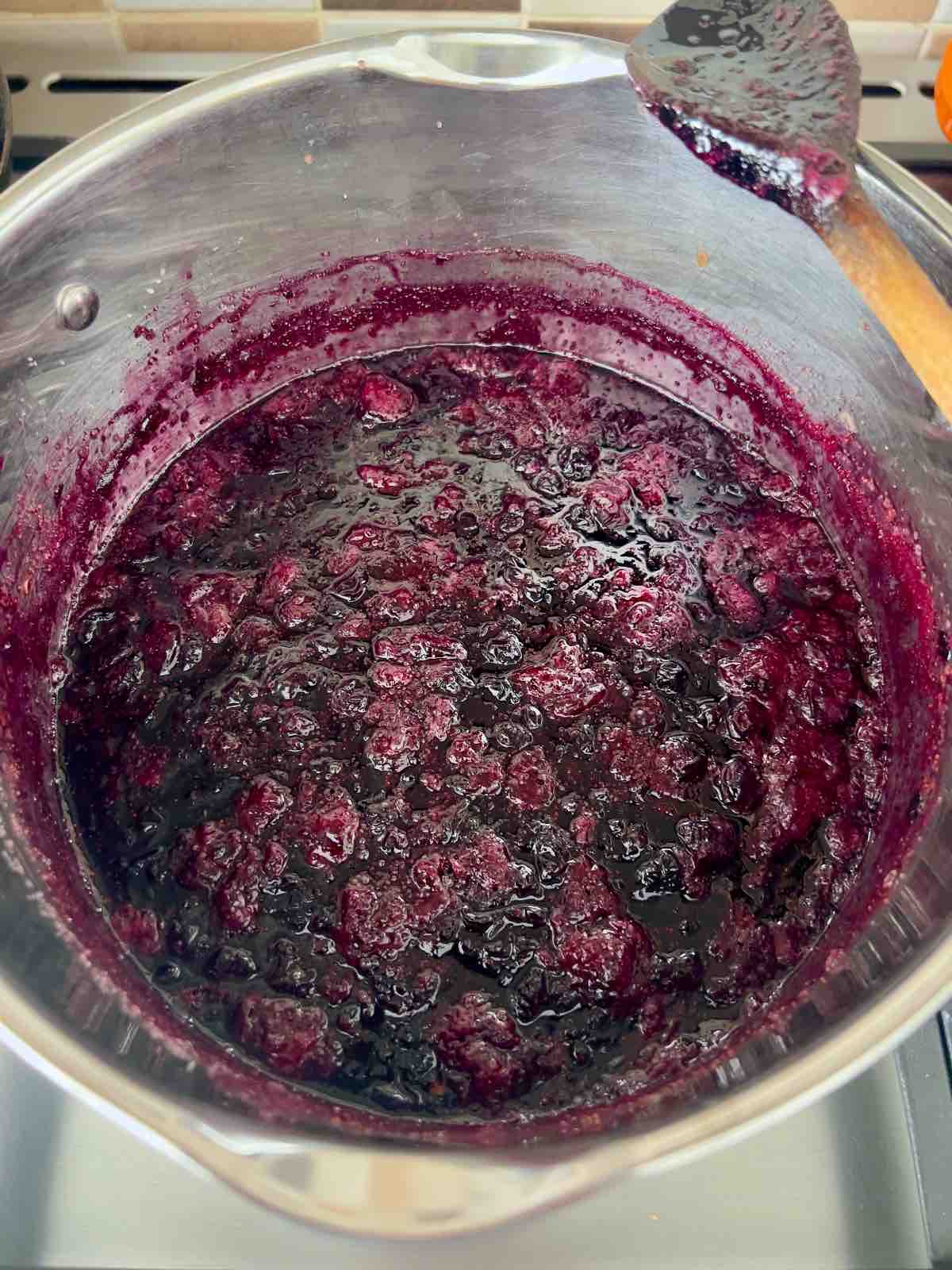 Blueberry jam in a pan after reaching setting point.