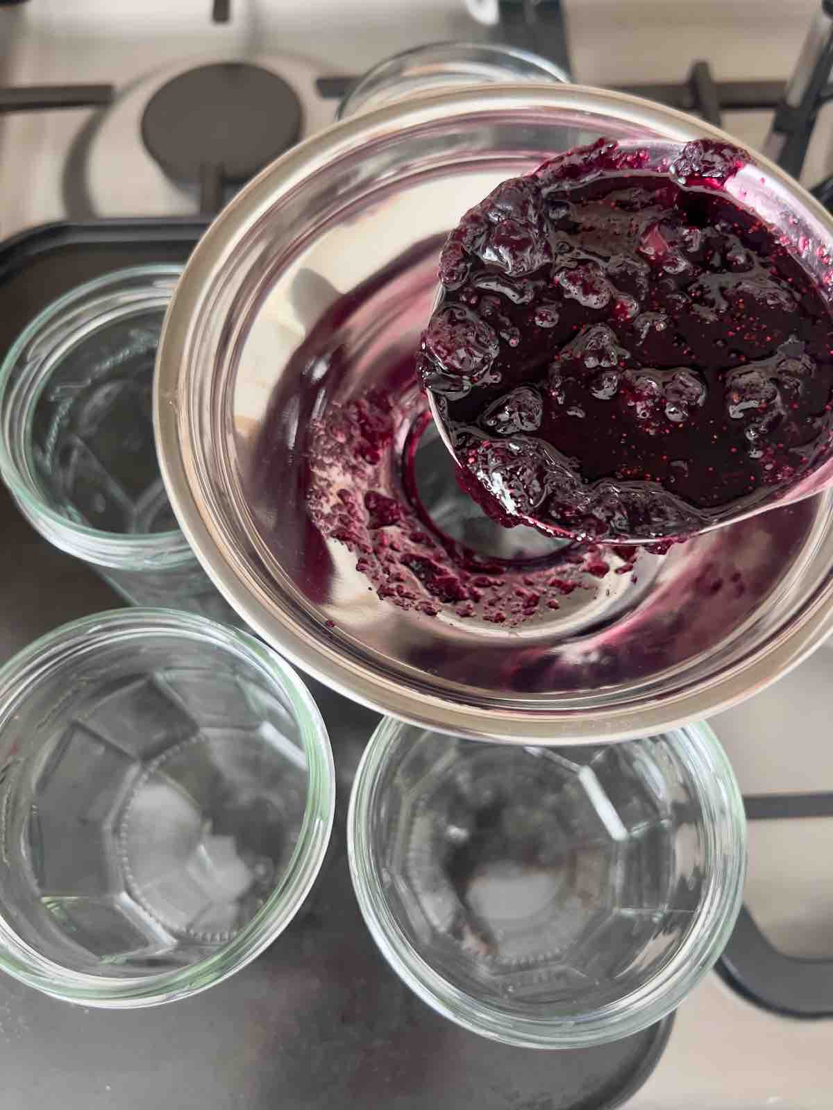 Filling jars with jam using jam funnel.