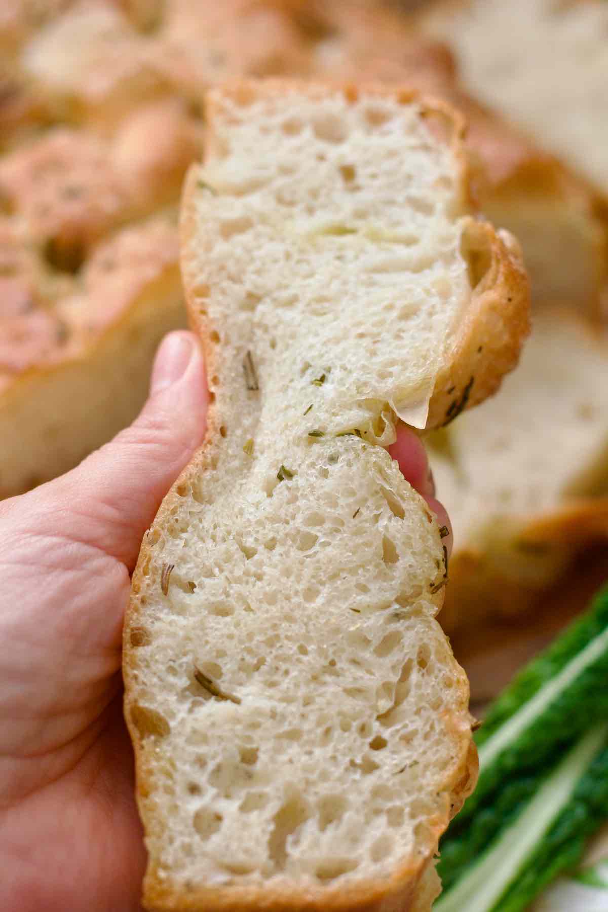 Hand squeezing a slice of focaccia.