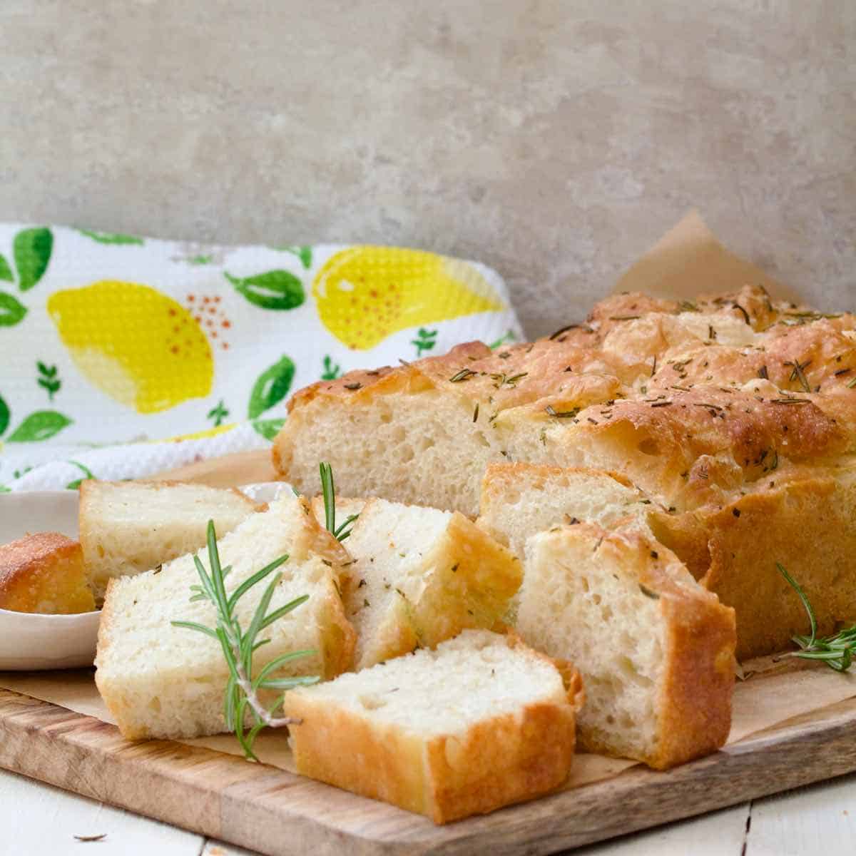Fluffy focaccia with few smaller pieces on the board.