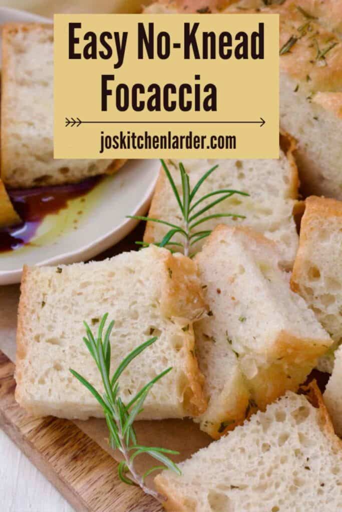 Focaccia pieces piled up on the board, garnished with fresh rosemary.