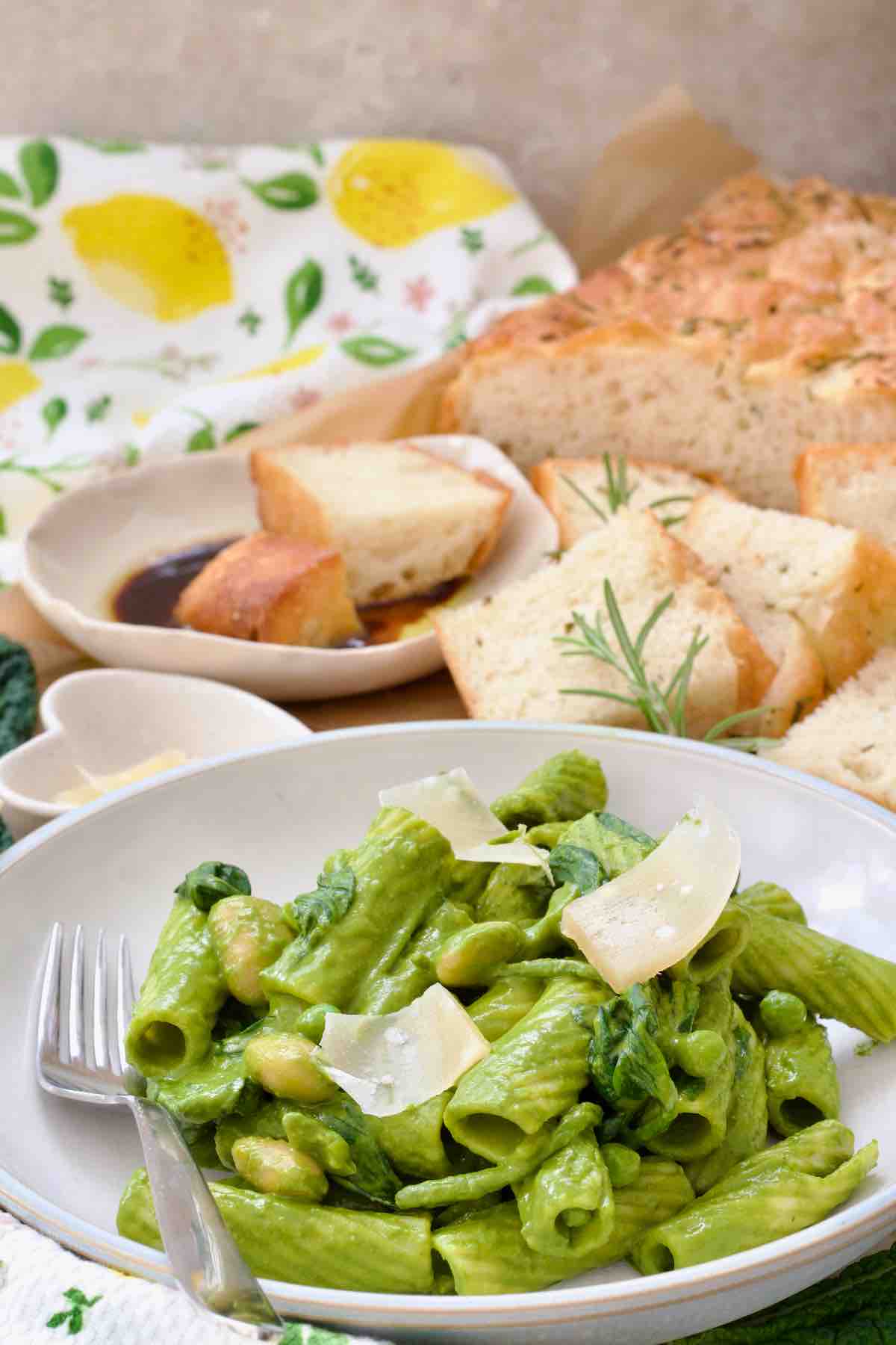 Bowl of easy green pasta and focaccia behind it.