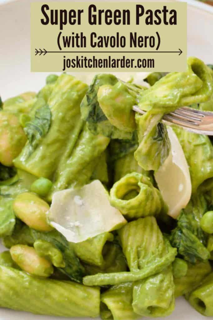 Close up of a bowl of green pasta with a bite ready on the fork.