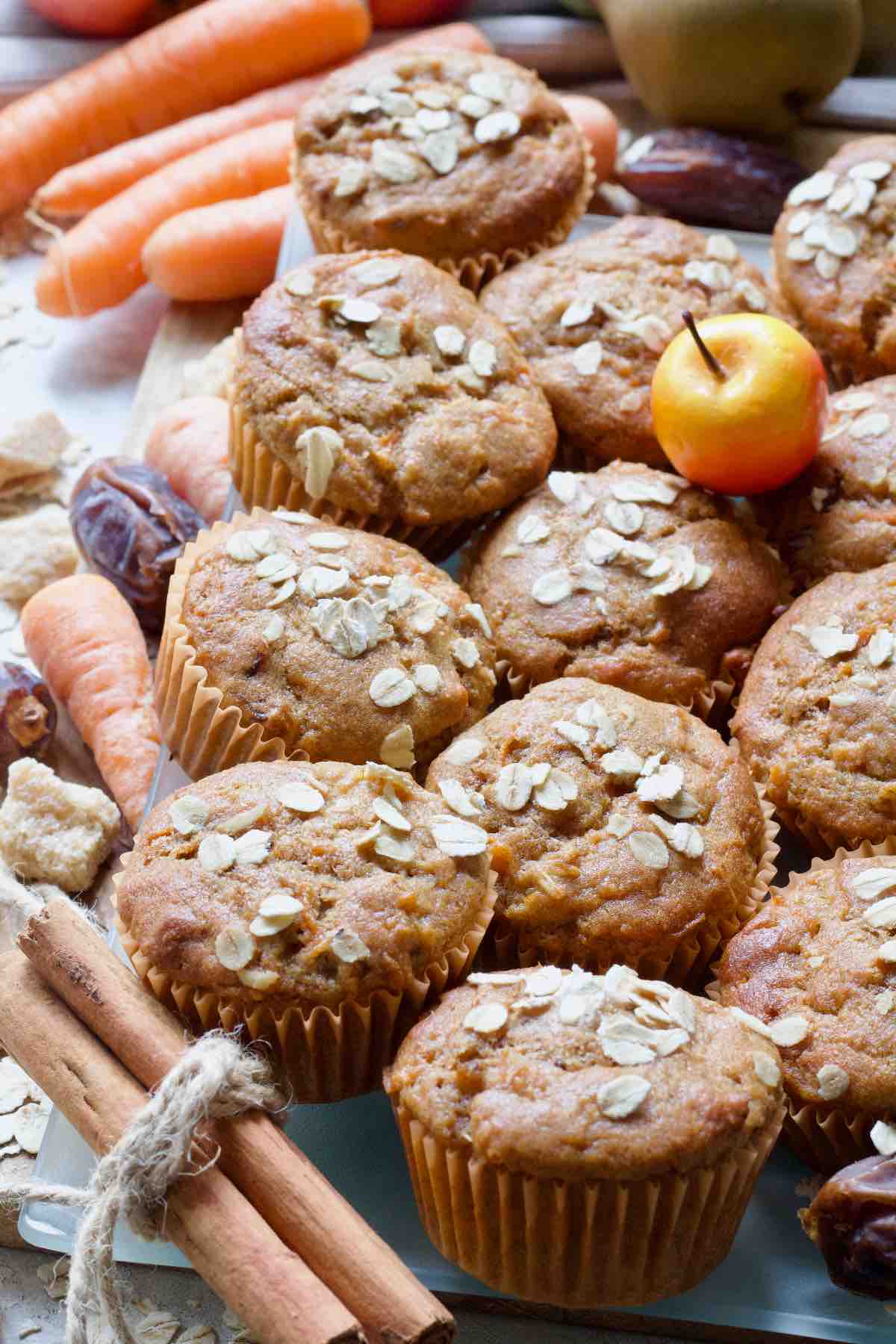 Platter with carrot and date muffins arranged close together, small apple on top.