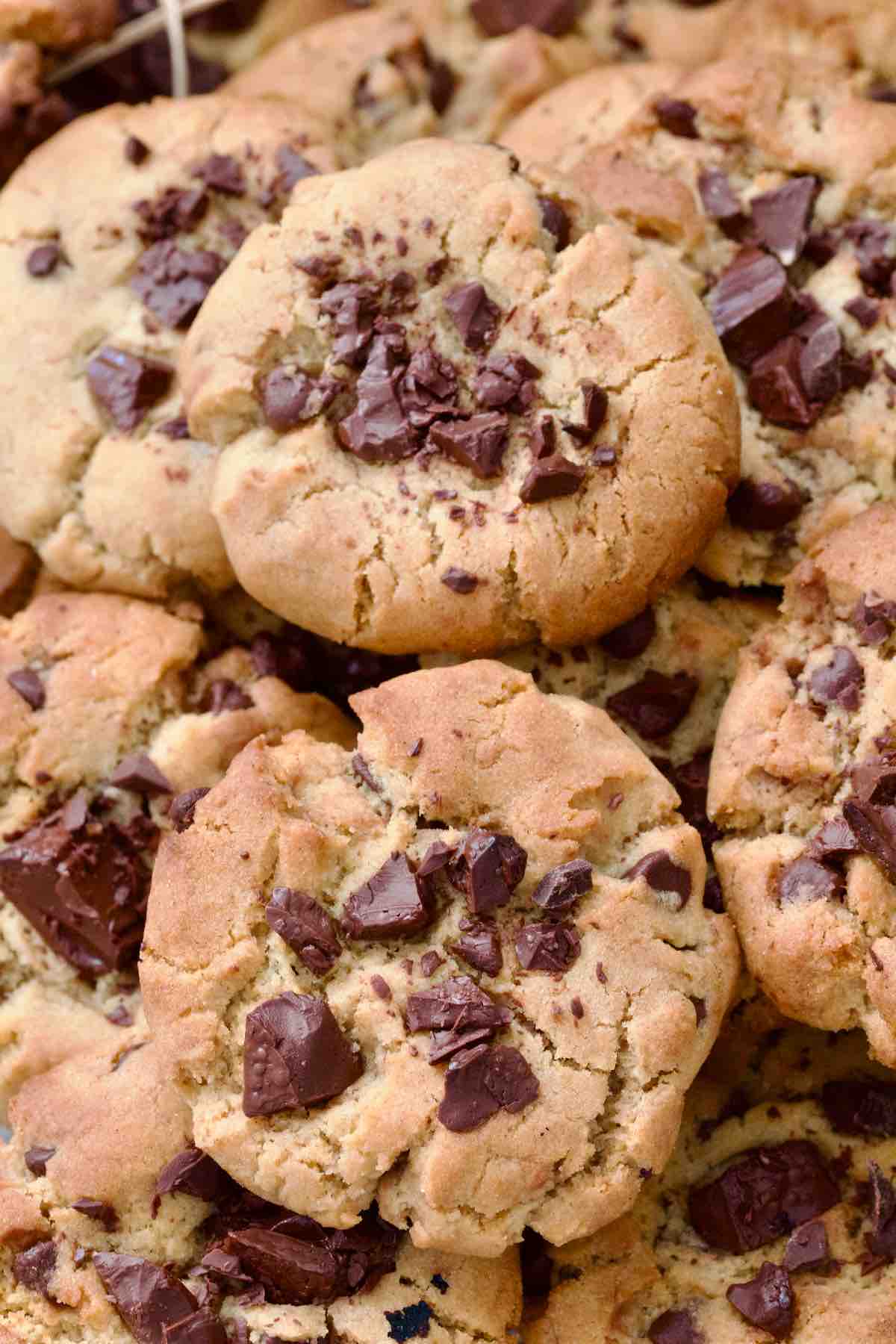 Two chocolate chip cookies piled on more cookies.