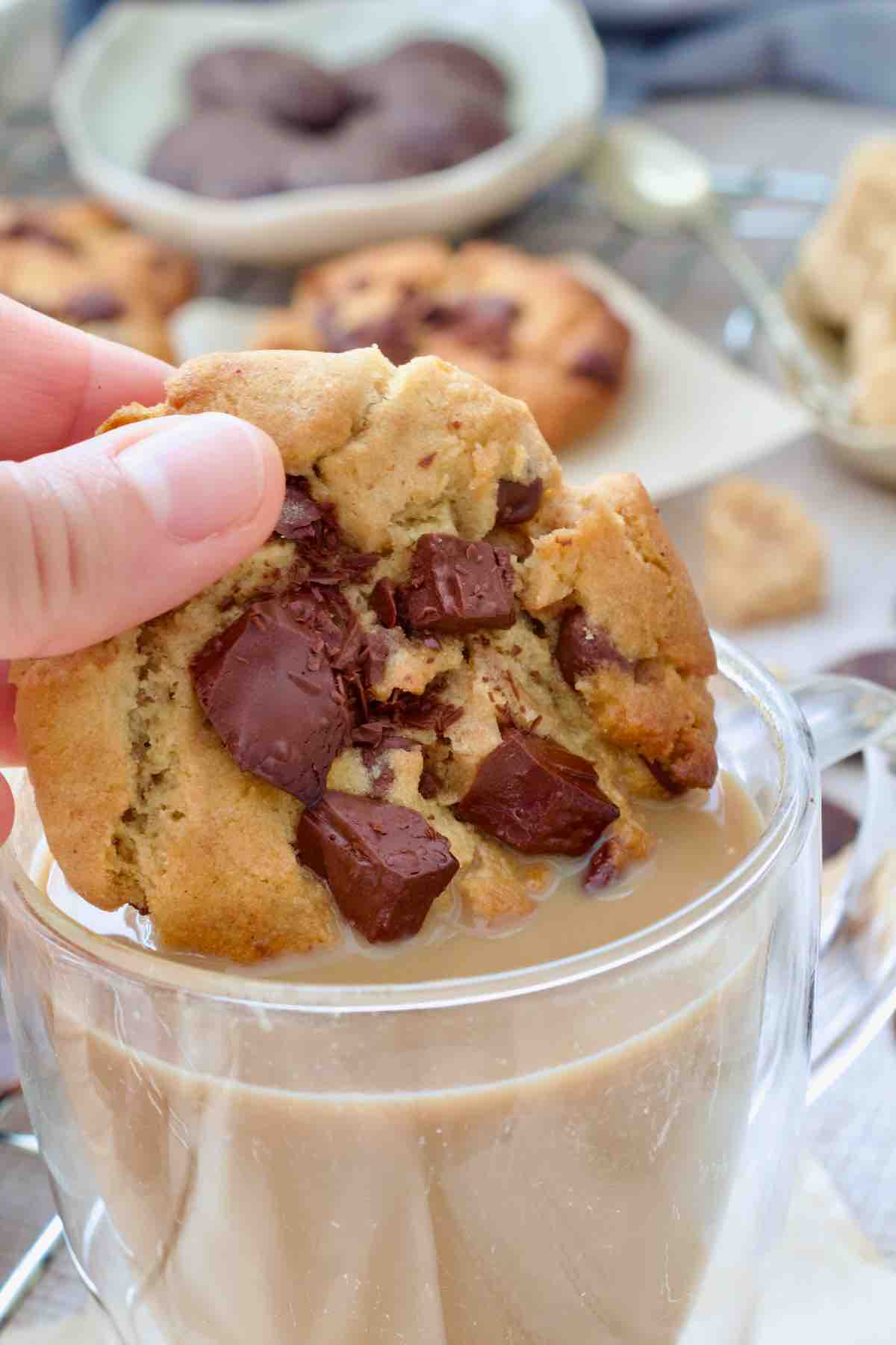 Hand dipping a cookie in a coffee.
